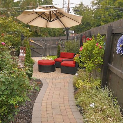 A stone path draws the eye to the seating area in the backyard garden of John and Beth Kocur.