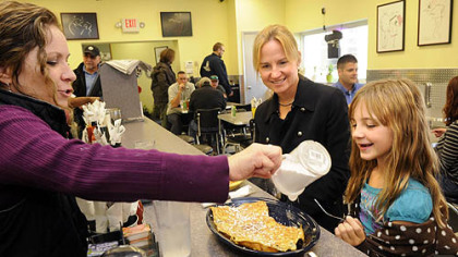 Kelly O'Connor sprinkles powdered sugar on French toast for Rachel Hardy, 8.  Rachel and her mom, Tammy, of Peters, stopped in for lunch after a doctor;'s appointment.  Tammy had pumpkin pancakes, claiming they were the best she has ever had.