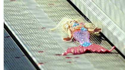 An abandoned mermaid doll left in the stands of Pittsburgh Obama International Studies Academy in East Liberty is surrounded by drops of blood after a shooting before a Saturday football game.