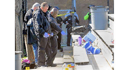 Pittsburgh police investigators look over the scene of the morning shooting in East Liberty on Saturday.