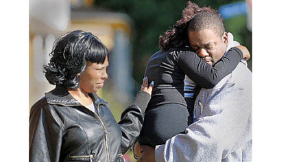 Robert Bailey comforts his daughter, Tasia, a cheerleader for the East End Raiders, following a shooting at a youth football game against Wilkinsburg in East Liberty on Saturday, as a woman also offers comfort.