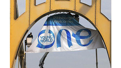 A crew installed a banner Oct. 5 on the Roberto Clemente Bridge for the One Young World Summit.