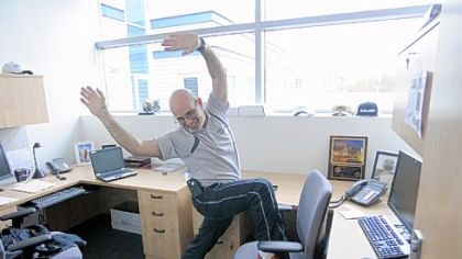 Ron DeAngelo, director of sports performance training at UPMC's Center for Sports Medicine, shows a hip flexing exercise you can do at your desk.