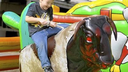 Garett Kime, 6, of Clarksville tries to hold on as he rides the mechanical bull Sunday at the 2012 Roughneck Fest at the Washington County Fairgrounds.