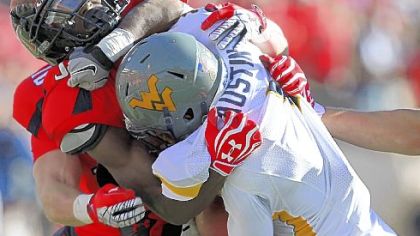 West Virginia's Tavon Austin is taken down by Texas Tech's Cody Davis Saturday in Lubbock, Texas.