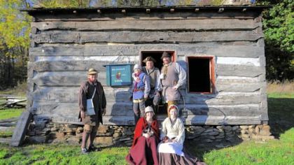 Re-enactors portraying people who lived during the Revolutionary War period are, seated in front, Jessica Baker, left, and Kate Cunning. Standing behind them are, from left, John Cunning, Nathan Baker, Rich Baker and Bryan Cunning. The group is outside of the Bloody Dirt Tavern at the Enoch Wright House in Peters. Bryan Cunning is known for his portrayal of George Washington.