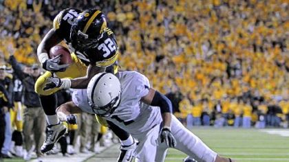 Iowa running back Adam Robinson, left, leaps over Penn State safety Nick Sukay in 2010. Iowa won, 24-3, and the Hawkeyes have won every home game against the Nittany Lions since '01.