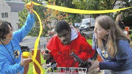 Dom Cole, 14, is assisted by physical therapists Sharon Hoffner, left, and Laura Dobrich as he wins his race.