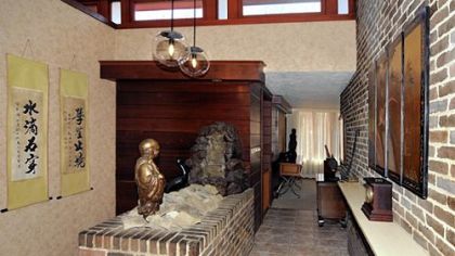 The entry has a porcelain-tile floor and redwood and brick walls.