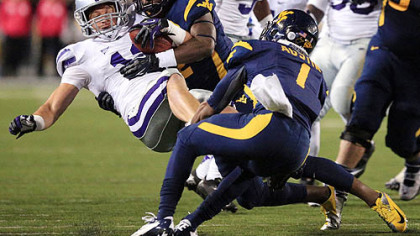 Kansas State's Ty Zimmerman, left, is tackled by West Virginia's Travares Copeland and Tavon Austin (1) following an interception during the third quarter.