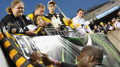 The Steelers' Antonio Brown signs a throwback jersey for a fan during pregame in Cincinnati.