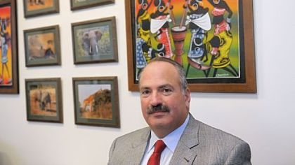 Michael Ginsberg, a partner with Jones Day law firm, sits with photographs and paintings from Kenya. Mr. Ginsberg volunteered his time to train trial lawyers in Nairobi.