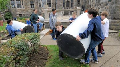 Sixth-graders move rain barrels at Temple Sinai's rainwater garden in Squirrel Hill.