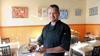Lola Bistro owner and chef Michael Barnhouse holds a plate of artisan cheeses and house charcuterie.