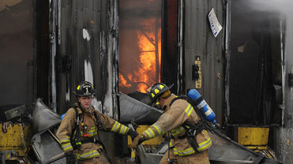 Firefighters move debris from in front of the Creps United Publications in Indiana County.
