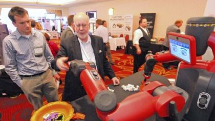 Rethink Robotics product manager Mike Bugda, right, demonstrates the Baxter user-programmable robot.