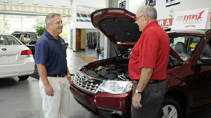 Harry "Good News" Gosnell, a salesman with Cochran Subaru in Monroeville, talks with customer David Goldblum of Connellsville.