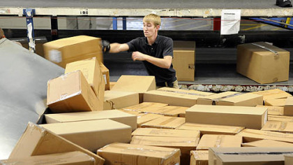 Ryan Craig, a load coach with Fed-Ex, sorts boxes at the Neville Isalnd facility.