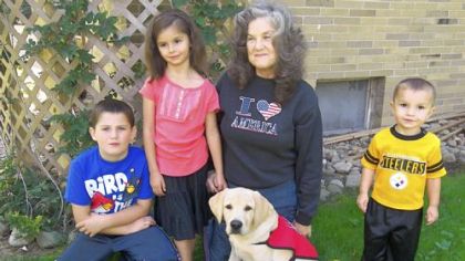 Rebecca Rodock of Penn Township is raising Remi to become a service dog. With them, from left, are her grandson, Chad Beckett, and great-grandchildren Kaylee and Silas Beckett.