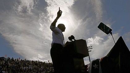 A silhouetted President Barack Obama gestures while speaking at a campaign event at Delray Beach Tennis Center, in Delray Beach, Fla.,