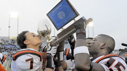 Clairton's Dakota Halcomb kisses the PIAA Class A trophy in 2011. The Bears are riding a 55-game winning streak.