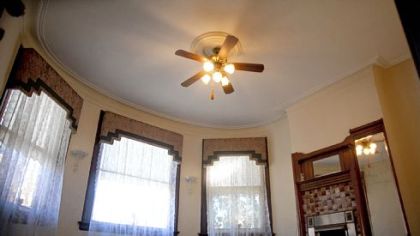 The 18- by 14-foot master bedroom is nestled in the turret. A fireplace and original mirror add interest to the curvy room.