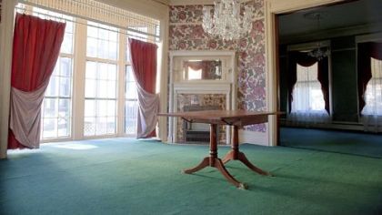 The dining room features large windows (there are 43 in the home), period wallpaper and the original fireplace mantel.
