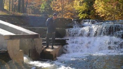 Fish and Boat biologist Ken Anderson looks for chromers at the bottom of a fish bypass channel that climbs around a waterfall on Fourmile Creek near Erie. The new bypass and nearby fish ladder provide steelheads and anglers with miles of additional access.