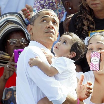 President Barack Obama carries a baby as he prepares to leave a campaign stop in Delray Beach, Fla., on Oct. 23.