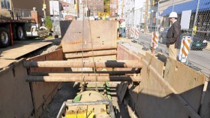 Senior project manager Tom Schwartzmier checks on the boring rig on McKee Place in Oakland.  The machine will bore under Forbes Avenue for placement of the pneumatic tubes.