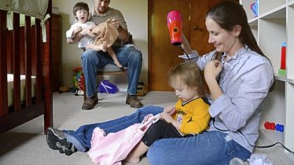 Attorneys Ryan and Summer Carroll get their twins, Jay and Lyla, 2, dressed after a nap at their home.