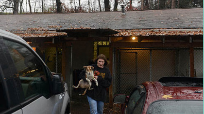 Staffer Deb Pechan carries a dog named Timmy as volunteers and the staff evacuate Orphans of the Storm animal shelter.