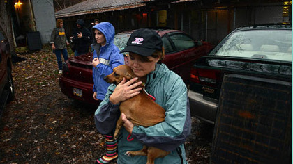 Debbi Reefer carries Tinkerbell, a dachshund, as volunteers and the staff of Orphans of the Storm, an animal shelter in Kittanning that sits close to the Allegeny River, work to evacuate animals in anticipation of possible flooding from Hurricane Sandy.