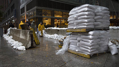 A working crew stacks sandbags beside concrete barriers to protect buildings near the World Financial Center in anticipation of massive flooding, Monday, Oct. 29, 2012, in New York.