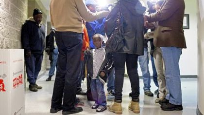 Hezekiah Finney, 3, the son of Conekia Finney, listens as his grandmother, Elaine Finney, talks to the media Wednesday before a press conference at the Ambridge Borough Building.