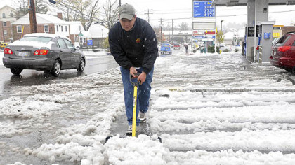 Angel Rodriguez, 22, removes snow at a gas station parking lot on Tuesday in Morgantown, W.Va.
