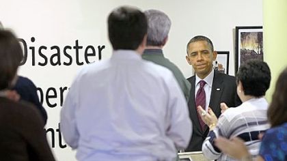 President Barack Obama receives applause Tuesday by workers at the Red Cross headquarters' Disaster Operation Center in Washington.