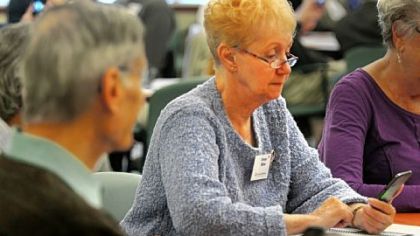 Evelyn Miller from Wilkinsburg looks over a smartphone at the Oct. 23 Senior TechRally at Longwood at Oakmont. The program helps seniors stay current as hand-held devices change.