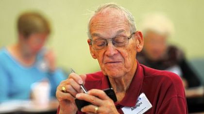 Denton Albright from Penn Hills works with a stylus to type on a smartphone at the Senior TechRally at Longwood at Oakmont.