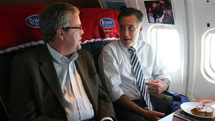 Republican presidential candidate Mitt Romney talks with former Florida Gov. Jeb Bush aboard his campaign plane on Wednesday en route to Miami.