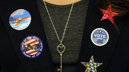 Elizabeth Vargo, a junior, sports buttons and stickers while managing the ballot boxes today.