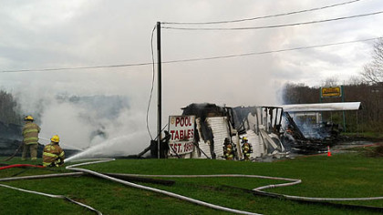 Water is poured on the fire at Valley Billiards along Route 119.