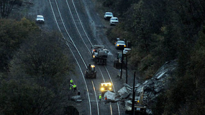 Crews work around sunrise to clear boulders on the Norfolk Southern railroad tracks above West Carson Street. The first train was able to pass the site by 7:24 a.m.