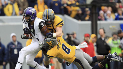 West Virginia's Jared Barber (33) and Karl Joseph (8) tackle TCU's Brandon Carter during the first half.