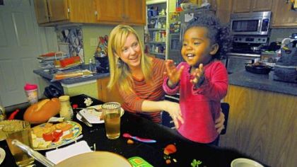 Amanda Szenyeri plays with her 20-month-old daughter Mae, an adoptee from Ethiopia, at their dinner table in Cranberry. Mae was adopted through All God's Children.
