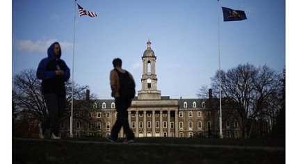 Students walk in front of the Old Main building on the Penn State campus in State College, Pa.