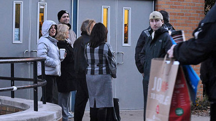 Voter wait outside at 6:45 a.m. at the entry to the poll in the city's Minadeo Elementary School.