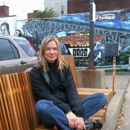 Landscape architect Rebecca Mizikar on the bench she designed at Penn Avenue and Winebiddle Street.