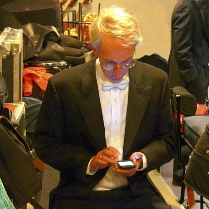 PSO cellist Hampton Mallory checks his email amid backstage chaos in Paris.