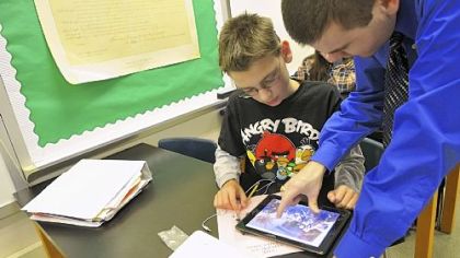 Eighth-grader Ben Deily, 13, works with his teacher Joe Welch, who helped develop a social studies book for North Hills Junior High Students using iBook Author, an app for tablets.